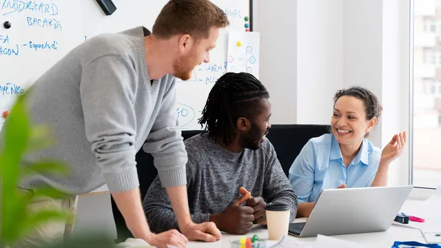 Colleagues collaborating over a laptop