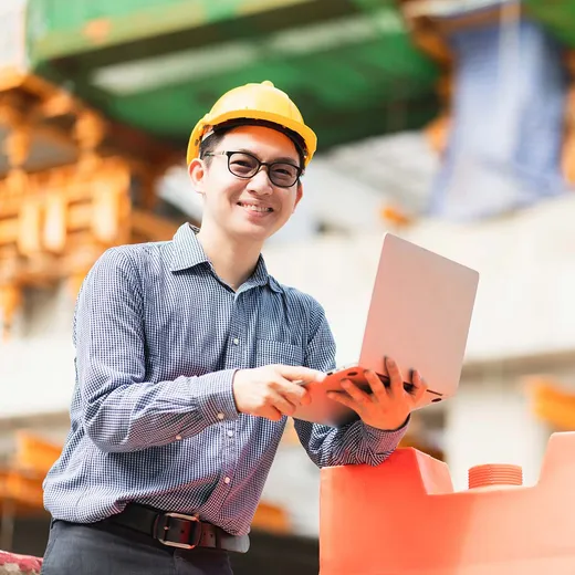 A civil engineer reviewing infrastructure data on a laptop
