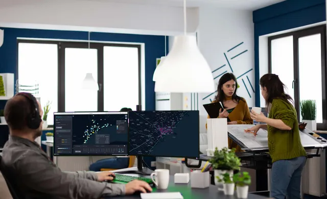 A GIS specialist working across dual monitors
