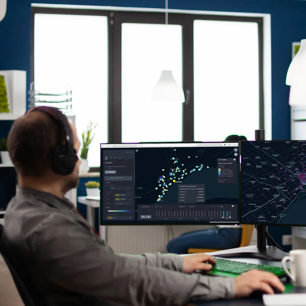 An employee using a dual-monitor GIS setup