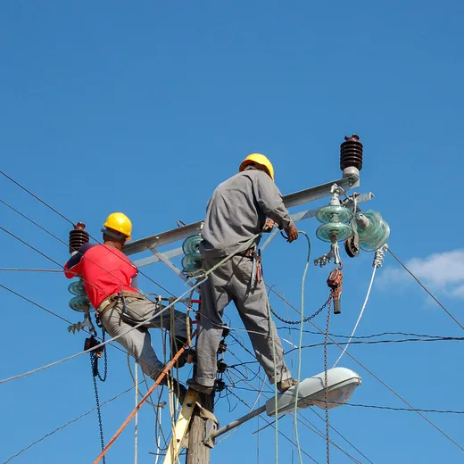 Electric linemen working on a power pole