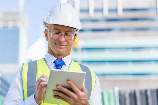 A developer reviewing plans on a tablet on-site